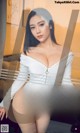 a woman in a white bodysuit posing for a picture