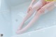 A woman sitting in a bathtub with her legs in the water.