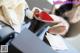 A woman sitting at a table with a pair of red and white shoes.