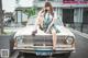 A woman sitting on top of a white car.