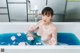 A woman sitting in a bathtub covered in foam.