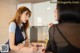 A woman sitting at a table talking to another woman.