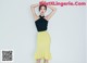 a woman in a black top and yellow skirt posing for a picture